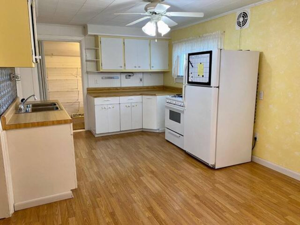 Kitchen with white cabinets, gas stove, and wood floors