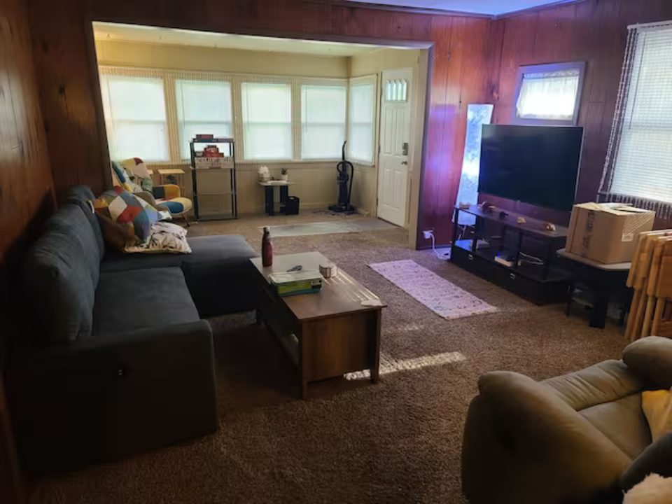 Living room and bright sunroom with a sectional sofa and coffee table